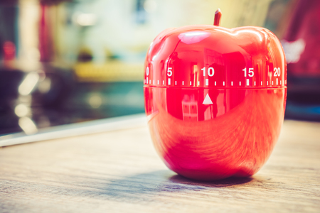 10 Minutes - A Red Kitchen Egg Timer In Apple Shape On Countertopの写真素材