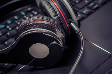 A Small Black Wired Gaming Headset Lying On The Keyboard Of A Notebookの写真素材