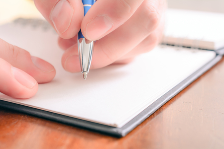 A Macro Of A Male Hand Writing In A Blank Organizer With A Biroの写真素材