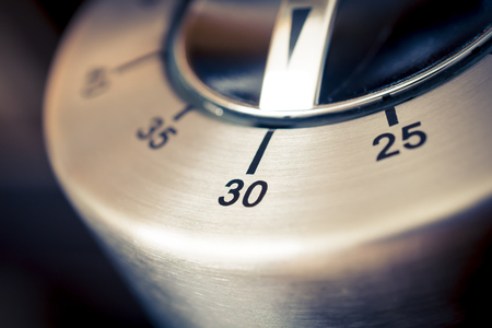 30 Minutes - A Macro Of An Analog Chrome Kitchen Timer With Dark Backgroundの写真素材