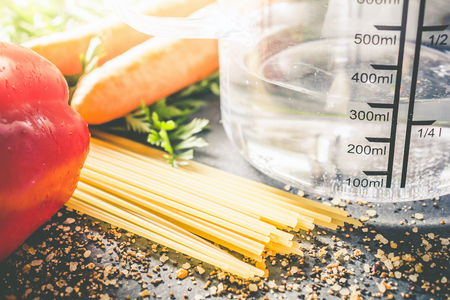 300 ml - ccm Water In A Measuring Cup Surrounded By Noodles, Pepper, Carrots And Spicesの写真素材
