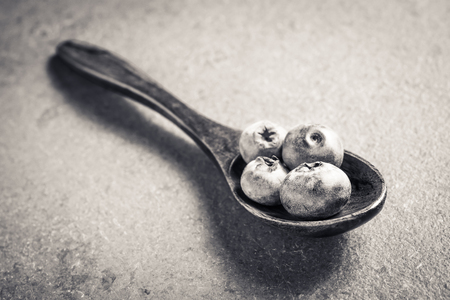 Bunch Of Blueberries On A Wooden Spoon On Slate Stone In Monochrome Colorsの写真素材