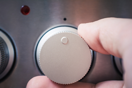 Front View Of A Male Hand Using Oven Controls, Oven And The Control Light Are Offの写真素材