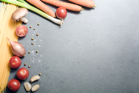 Top Down View On Kitchen Ingredients Like Noodles, Garlic, Onion, Tomatoes, Mushroom Or Spices On Slate Stone, With Copy Spaceの写真素材