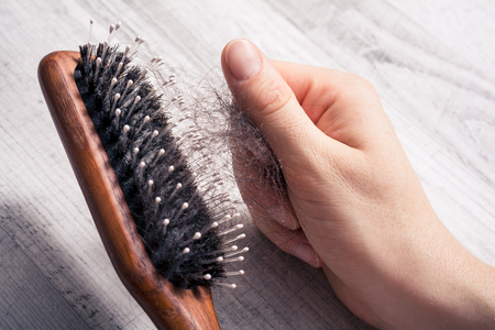 Female Hand Pulling Bunch Of Hair Out Of Brush - Alopecia Hair Loss Conceptの写真素材