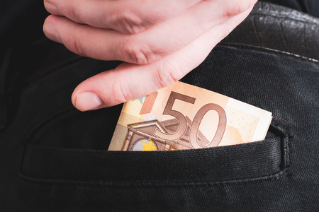 Male Hand Grabbing A 50 Euro Bill Out Of The Back Pocket Of A Black Jeans Trouser- Rich Man Conceptの写真素材