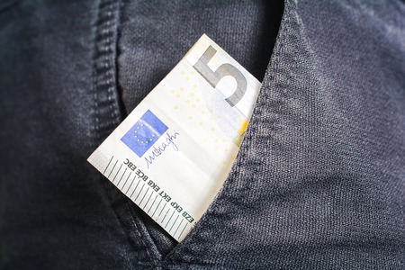 Half Of A 5 Euro Bill Showing Out Of The Pocket Of A Black Jeans Trouser - Poor Man Conceptの写真素材
