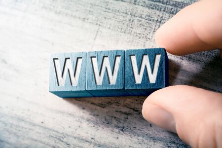 The Word WWW On Wooden Blocks And Arranged By Two Male Fingers On A Tableの写真素材