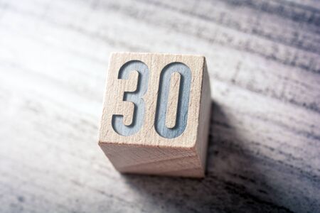 The Number 30 On A Wooden Block On A Tableの写真素材