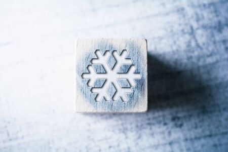 Snowflake Sign On Blue Wooden Block On A Tableの写真素材