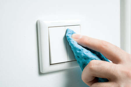 Cleaning A White Light Switch On A Wall With Wipeの写真素材