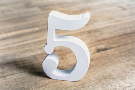 Number 5 Standing On A Brown Wooden Table