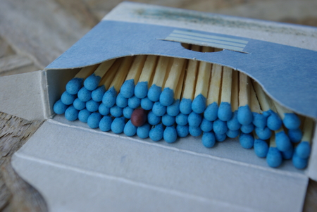 Standing out from the crowd. Close-up of a box of matches with one brown. Meaning of individuality, minority, racism, hospitality, gender equality, differences.の写真素材