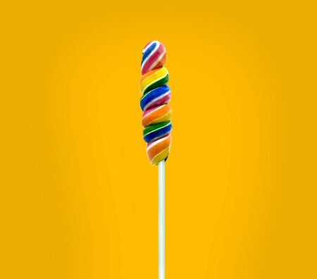 Shiny rainbow colorful sweet candy lollipop yellow backgroundの写真素材