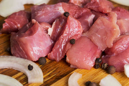 raw meat with onions on a wooden boardの写真素材