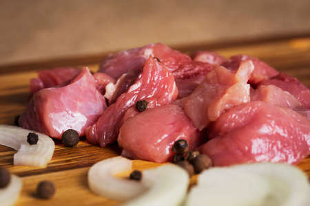 raw meat with onions on a wooden boardの写真素材
