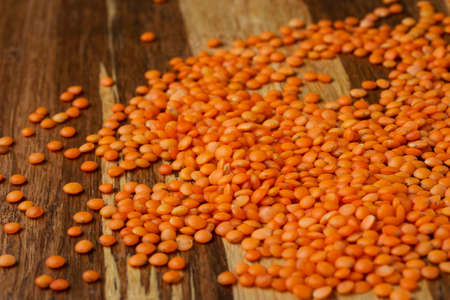 handful of red lentils on a wood backgroundの写真素材