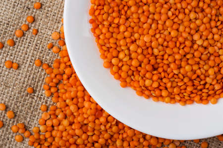 handful of red lentils on a background sackclothの写真素材