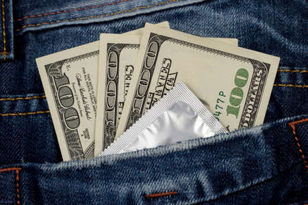 condom and money in a pocket jeansの写真素材