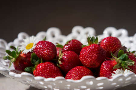 red ripe strawberries in a white vase for fruitsの写真素材