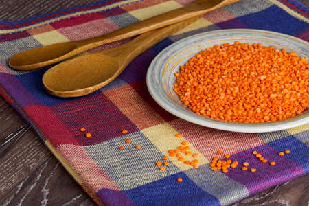 a handful of red lentils in a clay dishの写真素材