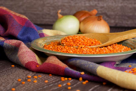 a handful of red lentils in a clay dishの写真素材