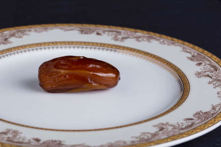 dried dates in a white plate on the tableの写真素材