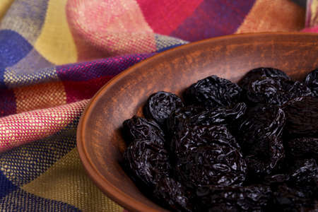 handful of prunes on a clay plateの写真素材