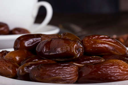 dried dates in a white plate on the table