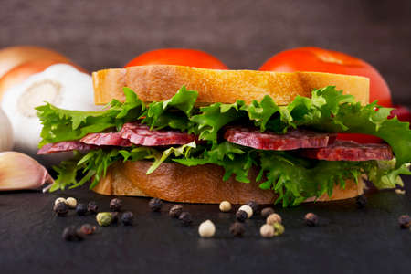 sandwich with sausage on a black tableの写真素材