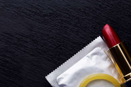 condom and lipstick on a black backgroundの写真素材