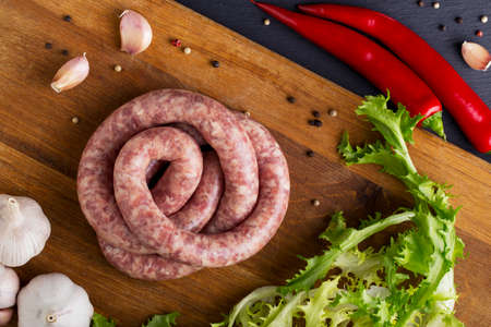 raw sausage and vegetables on a wooden tableの写真素材