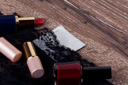 condom and lipstick on a wooden background