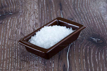 handful of rock salt on a wooden table
