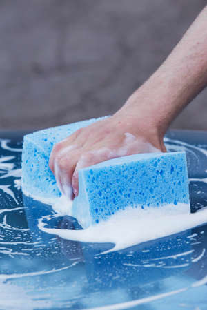 a turquoise car is washing in soap sudsの写真素材