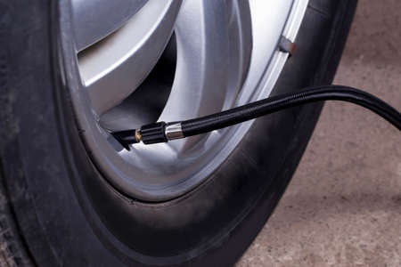 inflating the automobile wheels via a pumpの写真素材