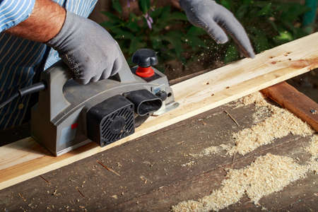 the carpenter is polishing a wooden board