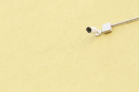 the surveillance camera on a wall of buildingの写真素材