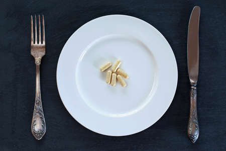 the medical pills in plate on a black backgroundの写真素材