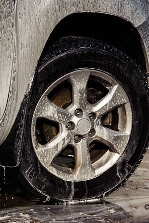 car wheel is washing in soap sudsの写真素材