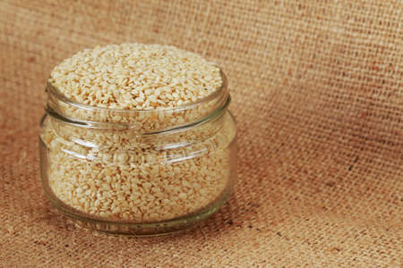 Sesame seed in a jar on fabrics backgroundの写真素材