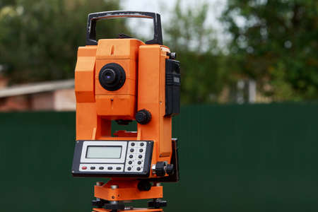 the orange theodolite is mounting on a tripodの写真素材
