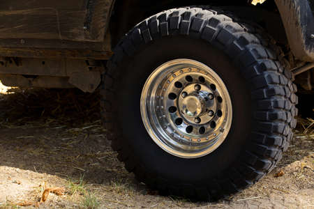 The big black wheel of an off-road car close-upの写真素材