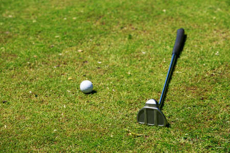 The golf-stick and ball close up in grassの写真素材