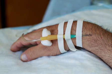The hand with needle of medical dropper