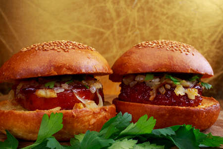 Homemade hamburger with fried onion on a wooden table