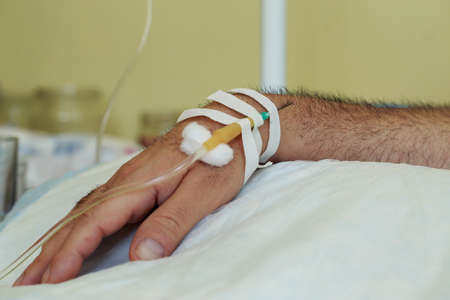 The hand with needle of medical dropper