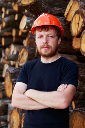 man in a helmet stands near the felled treesの写真素材