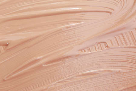 Texture of the liquid base beige on background