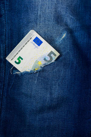 Five euro in a hole of jeans